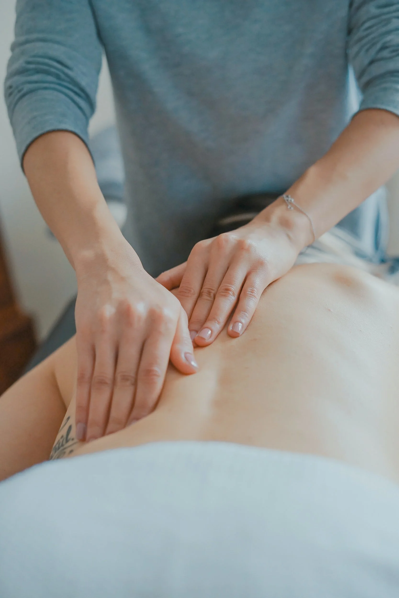 Therapist performing focused clinical massage on a client's back