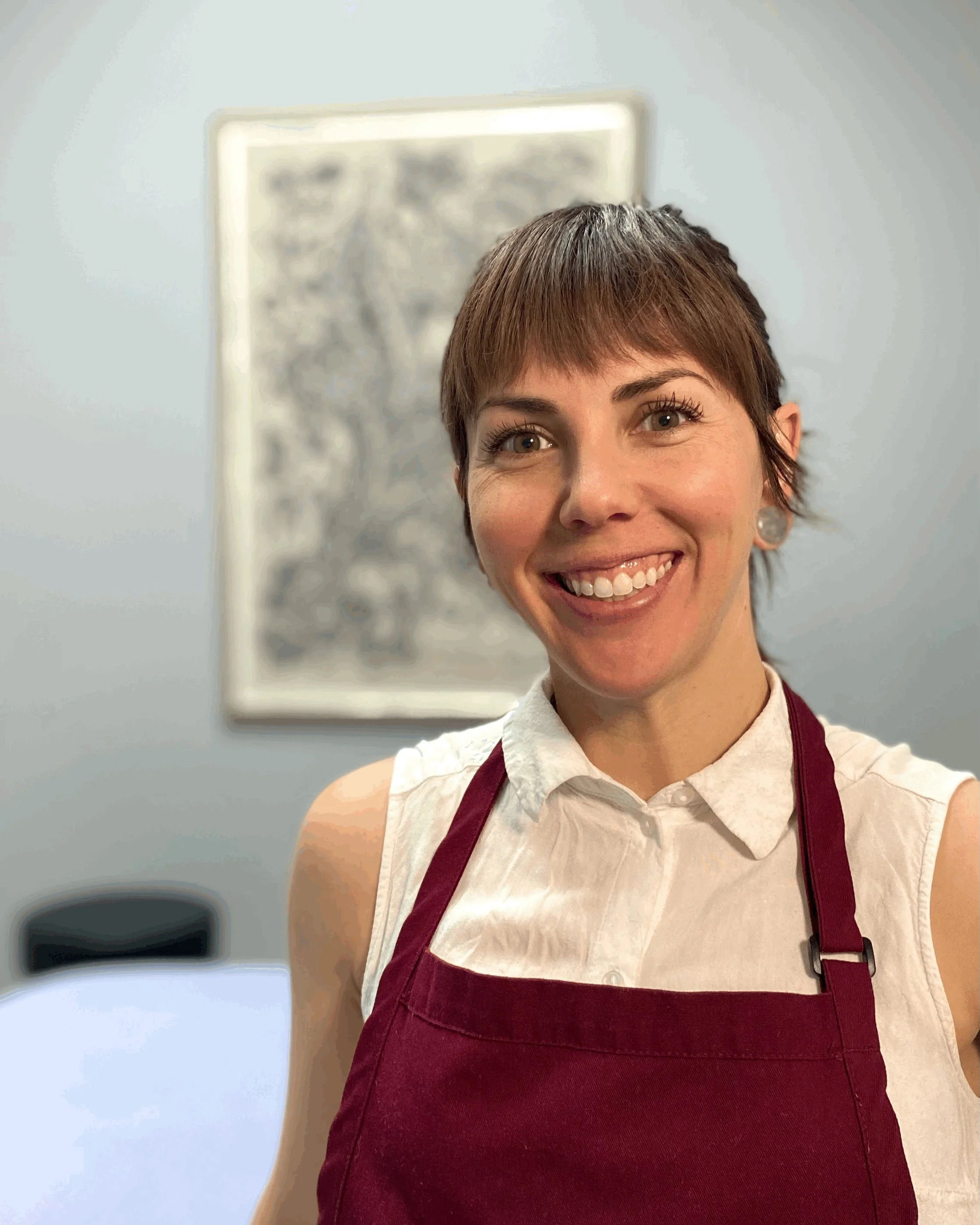 Sabrina Solis, Holistic Health Practitioner and Licensed Massage Therapist, smiling in her studio