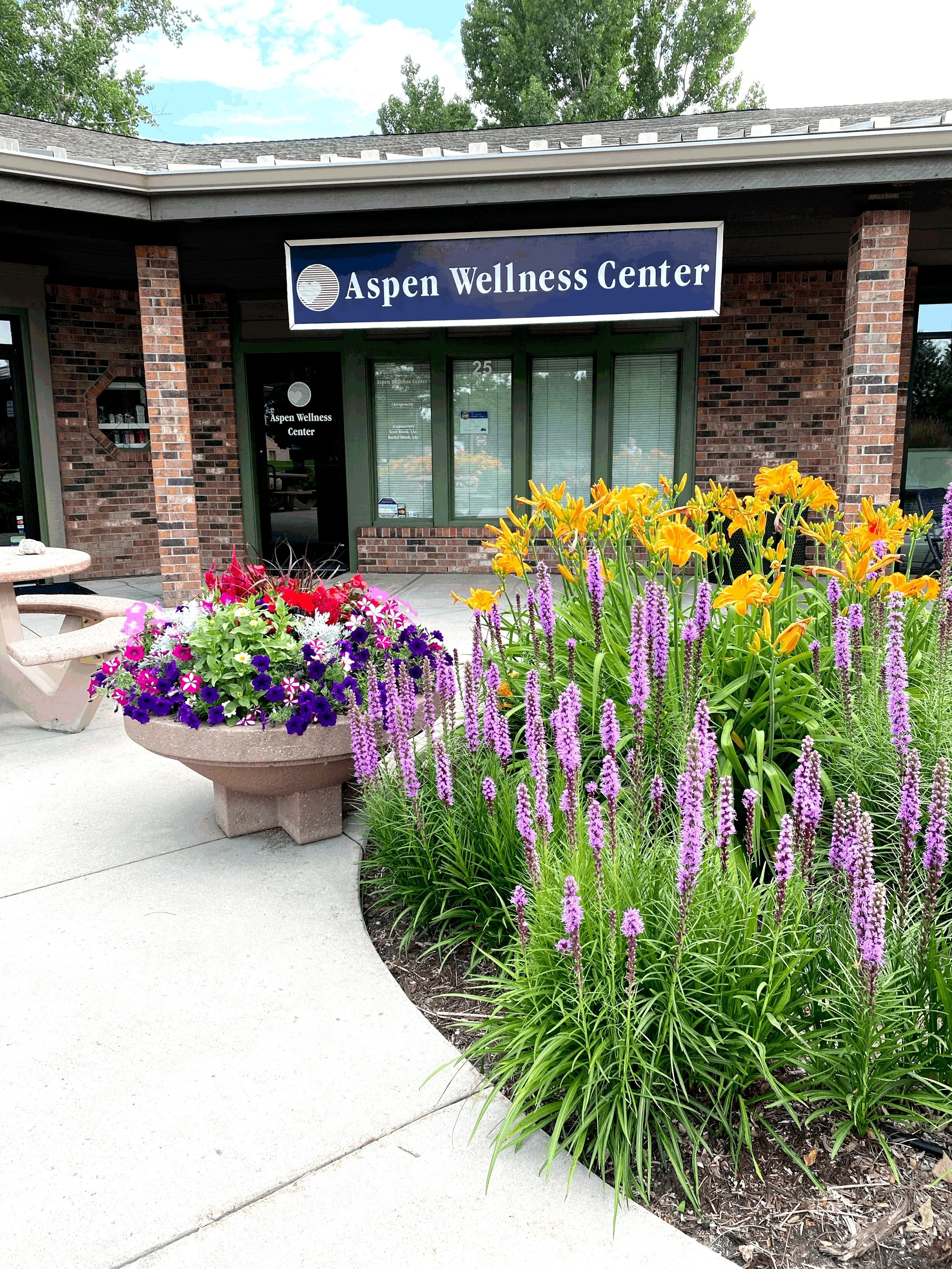 Exterior of the wellness center building with summer flower gardens in Fort Collins
